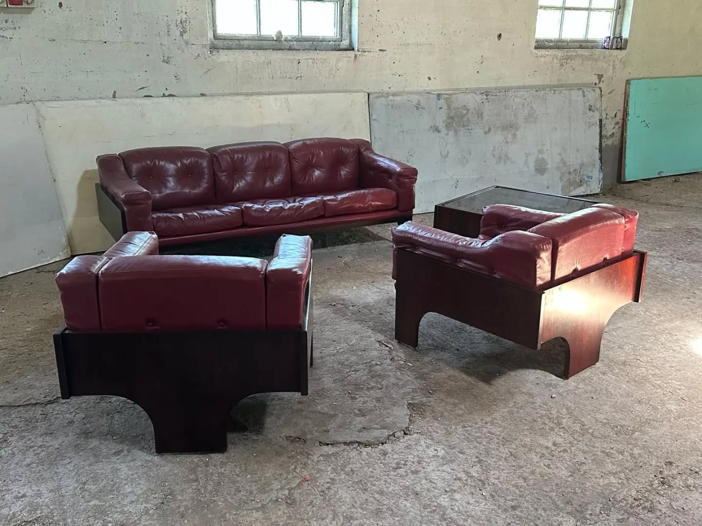Sormani – Rare Italian Lounge Suite in Rosewood & Burgundy Leather, Italy, c.1970s A striking and architecturally composed lounge suite by Sormani, crafted in luxurious Brazilian rosewood (palissandro) and upholstered in its original deep burgundy leather. The sculptural timber frame, with its bold cantilevered profile and elegant arched supports, perfectly reflects the refined sophistication of Italian design during the 1970s. The generously proportioned three-seat sofa and matching armchairs combine exceptional comfort with timeless aesthetics. Beautifully matured leather displays a rich patina acquired over decades, enhancing the authenticity and character expected by discerning collectors. The warm rosewood grain provides a dramatic contrast to the sumptuous upholstery, resulting in a piece equally suited to an important private residence or a carefully curated interior. An increasingly scarce and highly desirable ensemble from one of Italy's most respected manufacturers, offering understated luxury, impeccable craftsmanship and enduring investment appeal. #ItalianDesign #Sormani #BrazilianRosewood #MidCenturyModern #CollectorsPiece