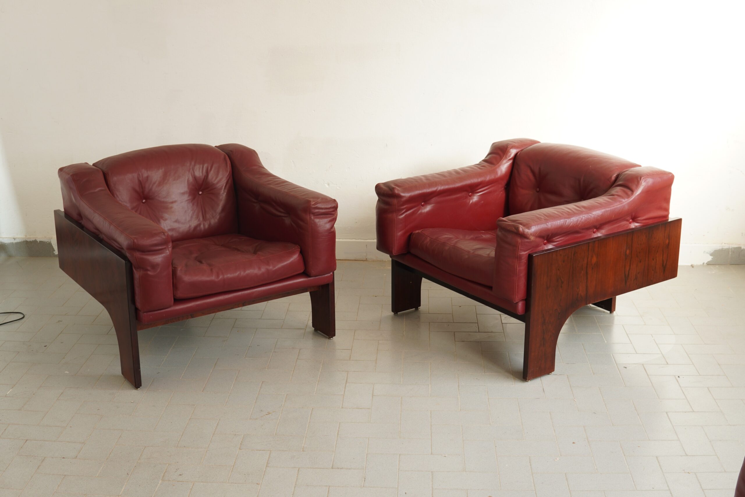 sThis stunning pair of mid-century modern "Oriolo" club armchairs was designed by Italian architect Claudio Salocchi for the prestigious manufacturer Sormani in 1966. They feature structured, geometric rosewood veneer side panels that anchor the design, beautifully juxtaposed with deep, button-tufted burgundy-red original leather upholstery.#InteriorDesign #MidCenturyModern #ItalianDesign #VintageLuxury #ClaudioSalocchi sold to a friend
