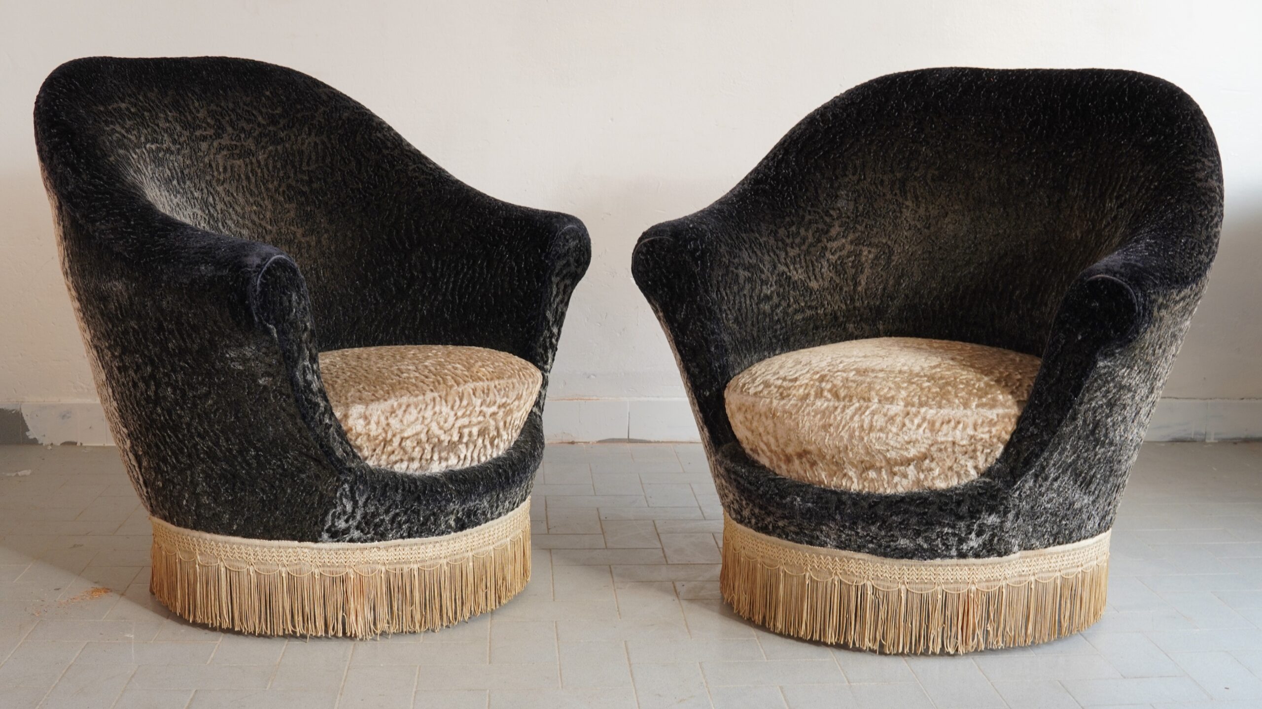 This exquisite pair of 1950s lounge armchairs, masterfully attributed to Italian designer Federico Munari, represents the pinnacle of mid-century high society elegance. They are presented in pristine, immaculate condition, retaining their highly coveted original vintage astrakhan-textured bouclé and arabesque velvet upholstery. The fluid, enveloping silhouette is perfectly complemented by the theatrical sophistication of the original bullion fringe base—a quintessentially opulent statement for the most discerning interior collector.#MidCenturyModern #FedericoMunari #ItalianDesign #VintageVelvet #luxuryantiques