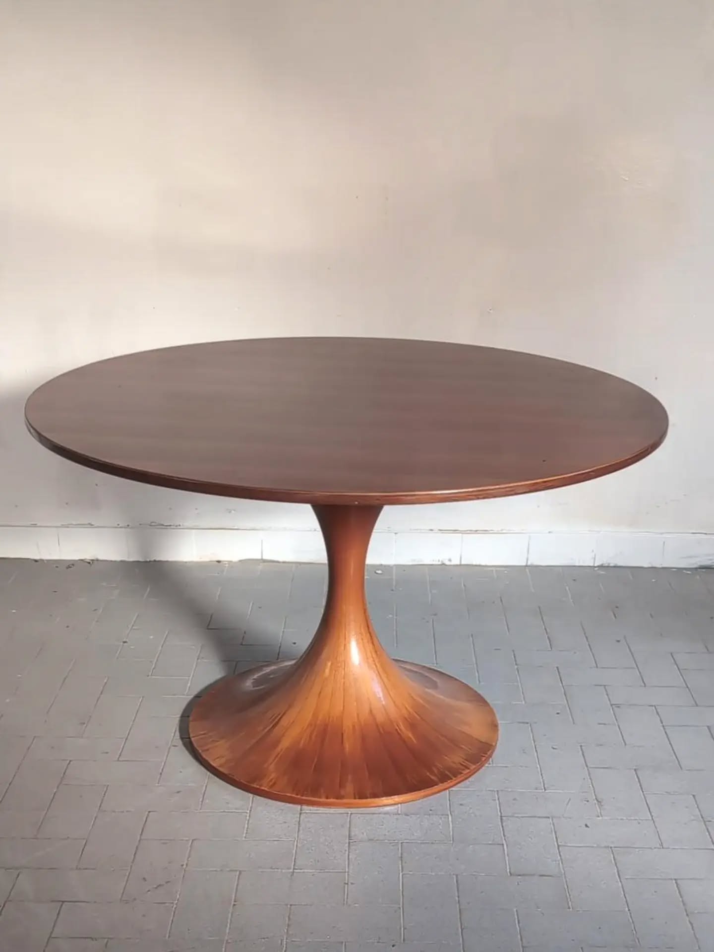Luigi Massoni for Mobilia — “Clessidra” Dining Table, circa 1959, an exceptionally elegant and increasingly sought-after example of post-war Italian design. The generous circular top is supported by Massoni’s remarkable hourglass pedestal: a beautifully resolved sculptural form whose slender waist opens gracefully towards the floor. Executed in Italian walnut and finished in a warm honey tone, the table possesses a richness and luminosity particularly suited to the purity of its silhouette. A design of considerable presence, Clessidra unites architectural discipline with the sensuality and superb cabinetmaking for which Italian furniture of the period remains unrivalled. Italy, circa 1959. #LuigiMassoni #Mobilia #ItalianDesign #MidCenturyModern #CollectibleDesign