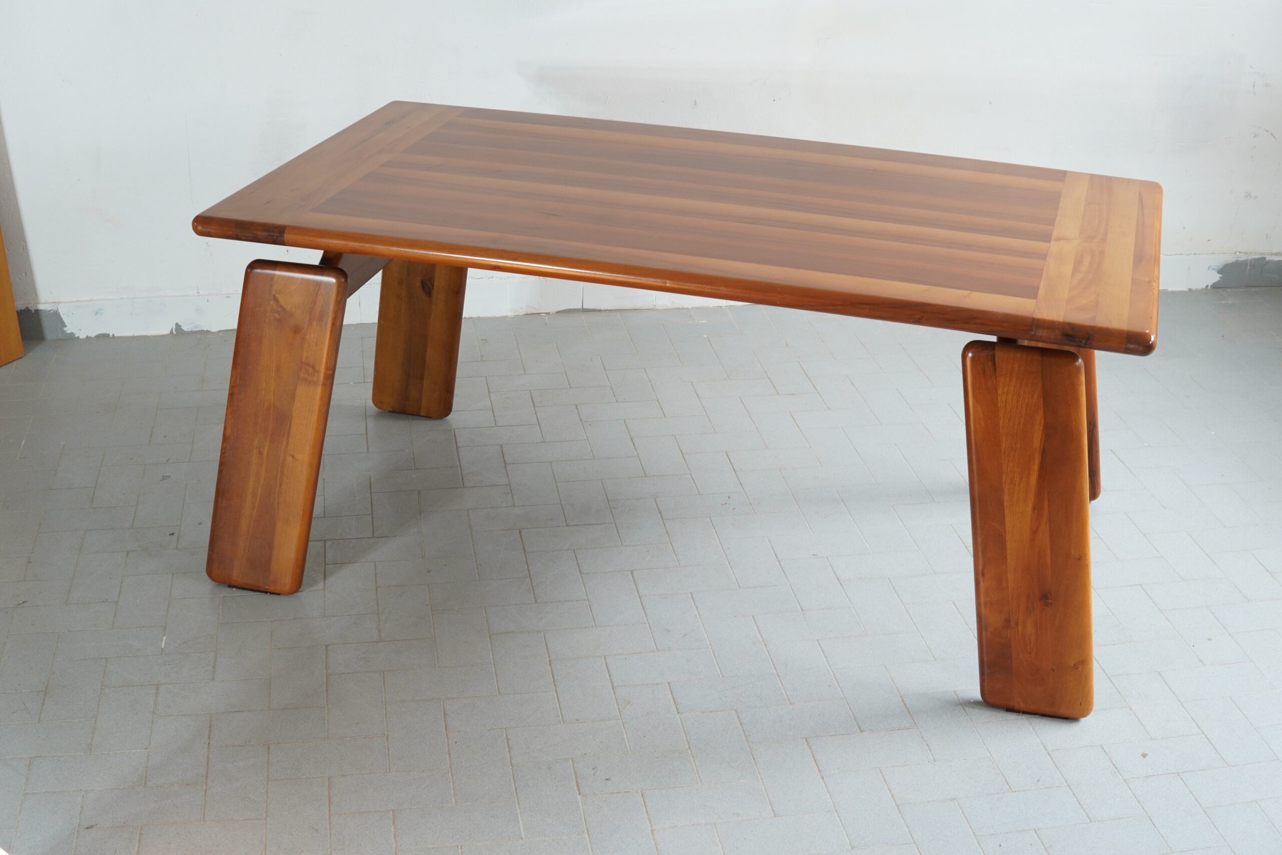 A Bespoke Mobilgirgi 'Sapporo' Dining Table: A Singular Commission One is presented with a rather extraordinary opportunity to acquire a truly singular piece of Italian design history: a bespoke Mobilgirgi 'Sapporo' dining table, executed in solid wood to a specific commission. Unlike the standard production models, this example was specially ordered by the original patron in a distinctly intimate size of 140 centimetres, rendering it an exclusive one-off that marries the brutalist elegance of the Sapporo line with a more domestic, convivial proportion. The table is a testament to the finest traditions of cabinetmaking, featuring the unmistakable, chunky cylindrical legs that define the Sapporo aesthetic. These are not merely supports but sculptural statements, their generous proportions softened by a superb, hand-finished patina that speaks of the wood's natural warmth and the passage of time. The tabletop, a masterpiece of joined timber, exhibits a rich, varied grain, ensuring that no two angles are alike. Perfect for the discerning collector who values the intimacy of a smaller dining setting without compromising on architectural presence, this piece is a rare foray into custom-made Italian furniture. It is not merely a table; it is a conversation piece—a slice of Mobilgirgi's heritage, tailored for a specific room and now seeking a new residence where its unique stature will be properly appreciated. #MobilGirgi #SapporoTable #BespokeFurniture #ItalianDesign #Woodcraft